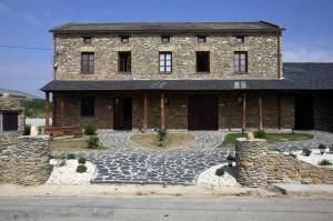 a large brick building with a stone driveway at Hotel y Apartamentos Penarronda Playa in Castropol