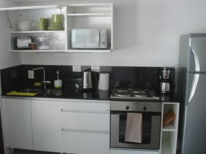 a small kitchen with a stove and a microwave at Premium Libertador in Florida