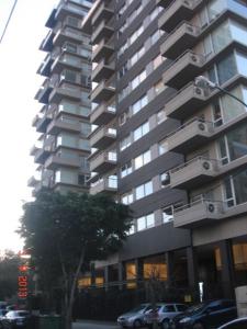 a tall building with cars parked in front of it at Premium Libertador in Florida