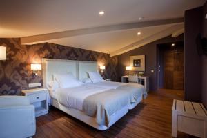 a bedroom with a large white bed in a room at Hotel Os Olivos in Guísamo