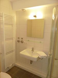 a bathroom with a sink and a shower with a mirror at Ferienapartment Blume in Meersburg +20 photos
