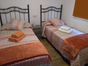 - deux lits assis l'un à côté de l'autre dans une pièce dans l'établissement La Maria Diego, à Peñamellera Baja