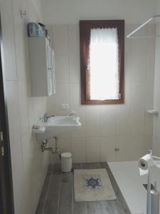 baño con lavabo y aseo y ventana en Agriturismo S. Agostino, en Rocchette