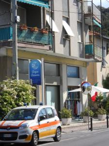 un coche blanco y naranja estacionado frente a un edificio en Appartamento Bordighera, en Bordighera