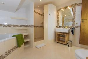 een badkamer met een bad, een wastafel en een toilet bij Hotel Alpenblick in Riedering