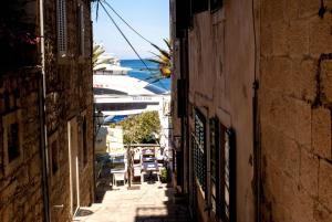 an alley way with a cruise ship in the water at Accommodation Old Town Vitaic in Korčula