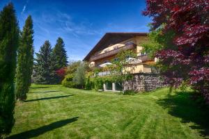 ein großes Haus mit einem Rasenplatz davor in der Unterkunft Hotel Weingarten in Naturns