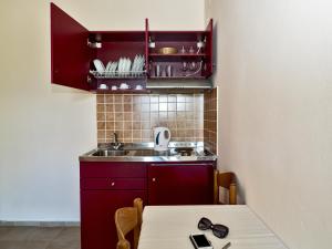 a small kitchen with a sink and a table at Sea Breeze Apartments in Lixouri