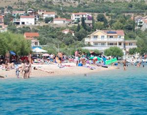 un grupo de personas en una playa cerca del agua en Sunce apartments en Grebaštica