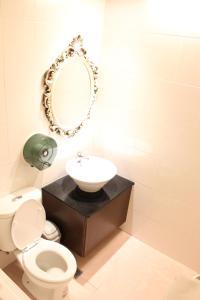 een badkamer met een toilet, een wastafel en een spiegel bij Full Moon Boutique Motel in Hsinchu City