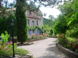 a street in front of a house with flowers at Les Rochers in Saint-Étienne-de-Gourgas