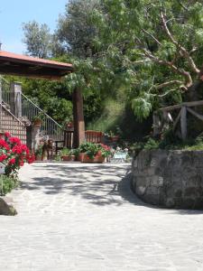 a walkway with flowers and a fence and trees at Agriturismo L'Olivara in Piano di Sorrento