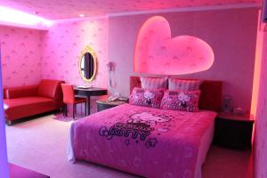 a pink bedroom with a pink bed with a heart headboard at Full Moon Boutique Motel in Hsinchu City