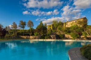 una grande piscina di fronte a una casa di Castello Di Petrata ad Assisi