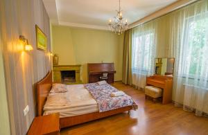 una camera con letto, scrivania e camino di Silver Hotel a Tbilisi City