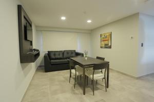 a living room with a table and chairs and a couch at Links Apart Hotel in Río Grande
