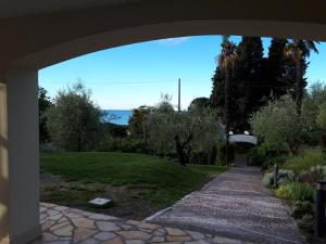 a view of a garden from under an archway at Albergo Blueline in Tellaro