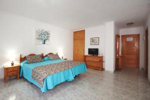 1 dormitorio con 1 cama y TV en Viviendas Vacacionales Marcial, en Morro del Jable