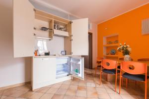 una cucina con armadi bianchi e pareti arancioni di Crispi Promenade a Cava deʼ Tirreni