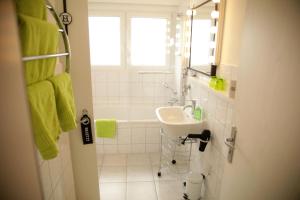 La salle de bains est pourvue d'un lavabo, d'une baignoire et d'une fenêtre. dans l'établissement Art City-Studios Kassel 4 und 8, groß, modern, citynah, je 3 Schlafzimmer, kostenfreie Parkplätze, Süd-Balkons, ruhig, Herkulesblick, à Cassel 49 autres photos