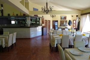 a restaurant with white tables and chairs and a bar at Pension Cuibul Viselor in Băile Herculane +65 photos