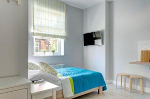 a small bedroom with a bed and a window at 3 City Apartments - Parkowy in Sopot