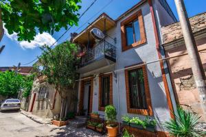 a house with a balcony on a street at Silver Hotel in Tbilisi City