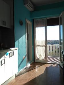 マロッタにあるDonatella Mini Apartmentの大きなガラスドア付きのキッチン、バルコニーが備わります。