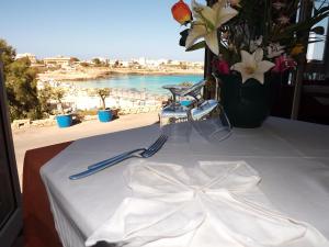 a table with a white table cloth with a view of the ocean at Hotel Giglio in Lampedusa
