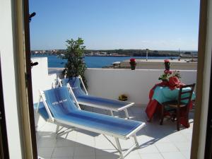 two blue chairs and a table on a balcony at Hotel Giglio in Lampedusa