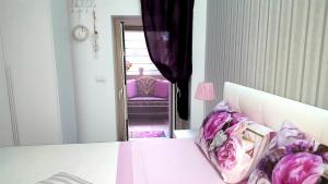 1 dormitorio con cama y silla morada en La Casetta Di Lori Ortigia, en Siracusa