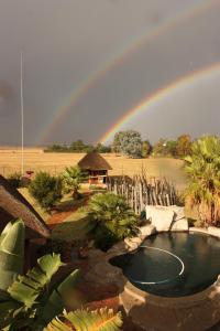 a rainbow over a garden with a swimming pool at Ikhamanzi B&B in Vereeniging
