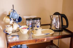 a glass table with a tea kettle and dishes on it at The Harp in Killarney