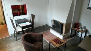 sala de estar con mesa y chimenea en La Petite Fugue, en Honfleur