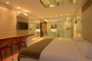 a bedroom with a large bed and a bar with red chairs at Le Ville in Ouro Preto