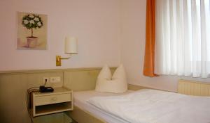 Zimmer mit einem Bett mit Kissen und einer Lampe in der Unterkunft Hotel Blume Post in Albstadt