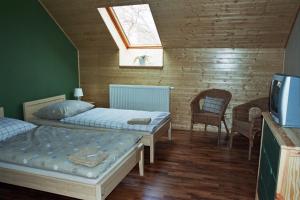 een slaapkamer met 2 bedden en een dakraam bij Penzion Ve stoleti in Loděnice