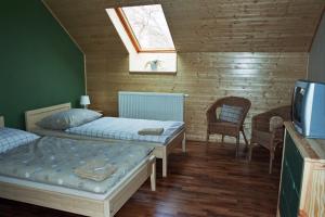 a bedroom with two beds and a skylight at Penzion Ve stoleti in Loděnice
