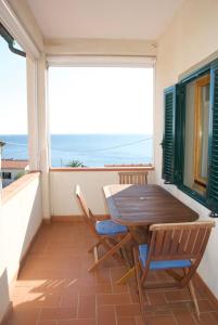 un tavolo e sedie su un balcone con vista sull'oceano di Casa Guerrino a Chiessi