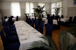 a dining room with white tables and blue chairs at Parkhotel Bellevue Budget in Lenk
