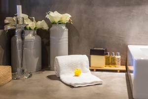 a bathroom with a towel and vases and a sink at TEIMA, Alentejo SW in São Teotónio