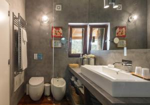 ein Badezimmer mit einem weißen Waschbecken und einem WC in der Unterkunft TEIMA, Alentejo SW in São Teotónio