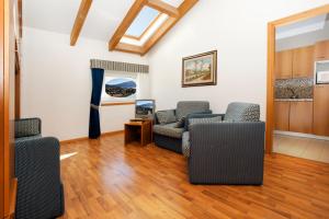 sala de estar con 2 sillas y mesa en Aparthotel Englovacanze, en Riva del Garda
