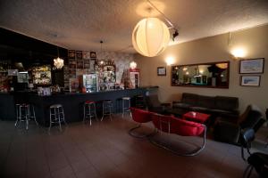 um bar num restaurante com bancos vermelhos em Alecrim Rosmaninho Guest House em Pinhel
