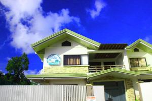 a white house with a clock on top of it at Casa Belina in Puerto Princesa City