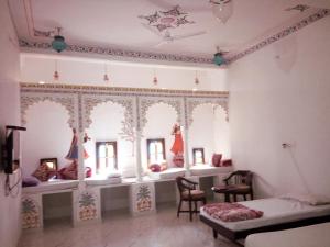 a room with a bed and some chairs and windows at The Royal Jag Villa in Udaipur