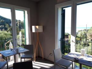 a dining room with tables and chairs and large windows at Albergo Blueline in Tellaro