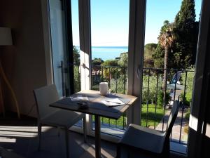 a table and chairs with a view of the ocean at Albergo Blueline in Tellaro