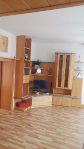 Stadtschenke في فيلاخ: غرفة معيشة مع دواليب خشبية وتلفزيون