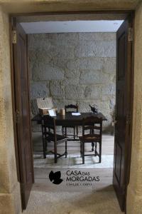 Habitación con mesa y pared de piedra. en Casa Das Morgadas, en Nelas